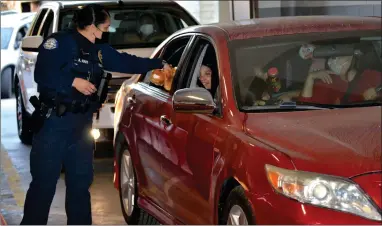  ?? RECORDER PHOTO BY ALEXIS ESPINOZA ?? Lindsay Police Officer Adriana Nave hands out a teddy bear during the city’s annual Santa Night on Friday evening hosted at the Lindsay Public Safety building.