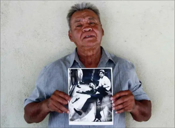  ?? JUD ESTY-KENDALL — STORYCORPS VIA AP ?? Juan Romero, 67, holds a photo of himself and the dying Sen. Robert F. Kennedy at the Ambassador Hotel in Los Angeles, taken by the Los Angeles Times’ Boris Yaro at his home in Modesto.