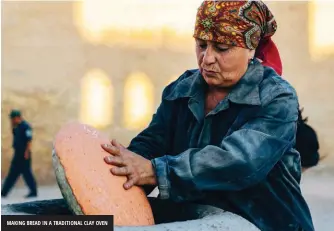  ??  ?? MAKING BREAD IN A TRADITIONA­L CLAY OVEN