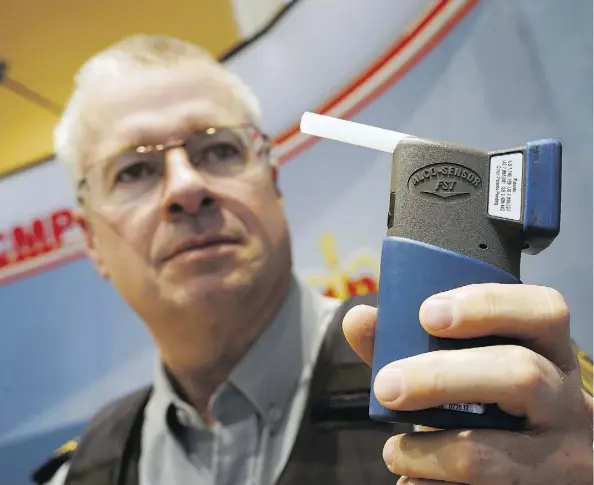  ?? LARRY WONG ?? RCMP Sgt. Brent Robinson, an impaired driving specialist, shows off a roadside screening device that will be used to test drivers for alcohol impairment. The upcoming change in legislatio­n will put mandatory alcohol screening into effect Dec. 18.