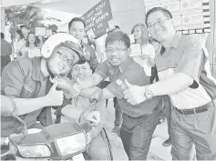  ??  ?? Herdiansah (second right) and Fariz (centre) during a road safety campaign held after the ceremony.