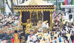  ??  ?? Hassanal and his queen, Pengiran Anak Hajah Saleha, wave from the royal chariot during a procession to mark his golden jubilee in Bandar Seri Begawan yesterday.