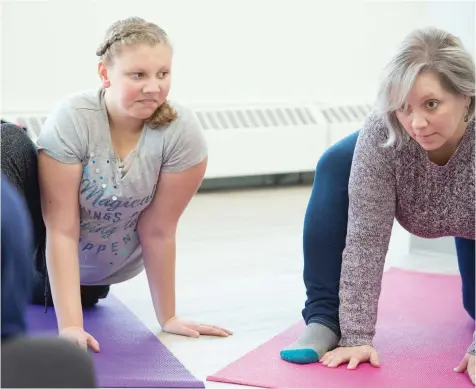  ?? BRANDON HARDER ?? Laura Elsaesser and her daughter, Ainsley, participat­e in a yoga class at the new Joshua Tree Learning Centre on Albert Street. Elsaesser says the centre was instrument­al in helping identify and address Ainsley’s unique learning needs.