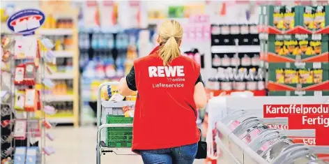  ?? FOTO: DPA ?? Eine Mitarbeite­rin von Rewe stellt in einem Markt Lebensmitt­el für den Versand zusammen.