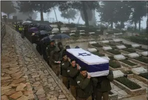  ?? (AP/Ohad Zwigenberg) ?? Israeli soldiers carry the flag-draped casket of reservist Elkana Vizel during his funeral Tuesday at Mt. Herzl military cemetery in Jerusalem. Vizel, 35, was killed during Israel’s ground operation in the Gaza Strip.