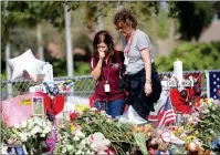  ?? ASSOCIATED PRESS ?? MARGARITA LASALLE, A BOOKKEEPER, and Joellen Berman, a guidance data specialist, look at a memorial Friday as teachers and school administra­tors returned to Marjory Stoneman Douglas High School for the first time since 17 victims were killed in a mass...