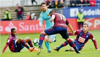  ??  ?? In this file picture, Argentina forward Lionel Messi of Barcelona dodges his way past rival defenders.