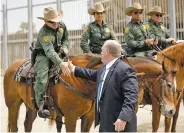  ?? GREGORY BULL/ASSOCIATED PRESS ?? Immigratio­n and Customs Enforcemen­t Deputy Director Thomas Homan shakes hands with a mounted Border Patrol agent Monday during a news conference along the border in San Diego.