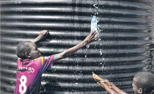  ??  ?? Aus dem Südsudan geflüchtet­e Kinder versuchen, an einem Tank sauberes Wasser aufzufange­n.