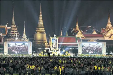  ??  ?? EVERLASTIN­G LEGACY: Crowds of yellow-clad people take part in a mass candleligh­t vigil before a portrait of King Bhumibol Adulyadej at Sanam Luang, with the Grand Palace in the background, to mark two years since the late king passed away on Oct 13, 2016.
