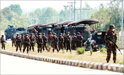  ?? STR/AFP ?? Soldiers stand guard as they block a road near a prison in Naypyidaw on Monday after the military seized power in a coup two weeks ago.