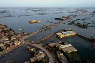  ?? (AP) ?? Homes are surrounded by floodwater­s in Sohbat Pur city, a district of southweste­rn Baluchista­n province