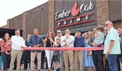  ?? PHOTOS BY JACOB WILT/THE COMMERCIAL APPEAL ?? Southaven Mayor Darren Musselwhit­e, Jeff Blankenshi­p, Les Hooper and family and friends prepare to cut the ribbon at Ember & Oak on Wednesday. The restaurant is located at 5915 Getwell Road in Southaven.