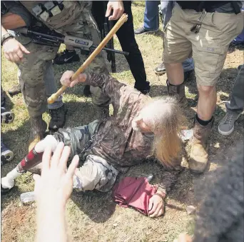  ?? JOHN BAZEMORE — THE ASSOCIATED PRESS ?? A man falls after being hit by counter demonstrat­ors during a protest , Saturday, Aug. 15, 2020, in Stone Mountain Village, Ga.