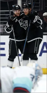  ?? HARRY HOW — GETTY IMAGES ?? The Kings' Trevor Moore, right, celebrates with Viktor Arvidsson after scoring one of his three goals against the Seattle Kraken.