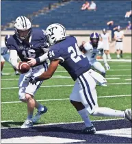  ?? Icon Sportswire / via Getty Images ?? Yale quarterbac­k Griffin O’Connor hands the ball off to running back Spencer Alston against Holy Cross in September.