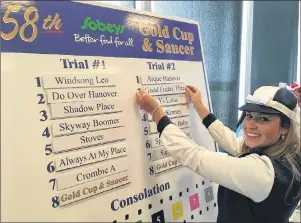  ?? CHARLES REID/THE GUARDIAN ?? Gold Cup and Saucer ambassador Juli MacMillan, 19, places the card of Good Friday Three, her representa­tive horse, on the board setting the order in the trials for the Maritimes top harness racing prize on Tuesday in Charlottet­own. Good Friday Three is owned by 95-year-old Summerside resident Walter Simmons.