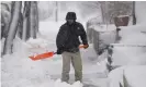  ??  ?? A man clears snow from the walkway of his home in Denver on Sunday. Photograph: David Zalubowski/AP