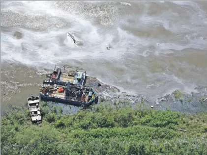  ?? CP PHOTO ?? Crews work to clean up an oil spill on the North Saskatchew­an river near Maidstone, Sask. on. Husky Energy has said between 200,000 and 250,000 litres of crude oil and other material leaked into the river on Thursday from its pipeline.