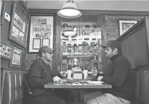  ?? JOSHUA A. BICKEL/COLUMBUS DISPATCH ?? Coworkers Don Binns, left, and Matt Adams have lunch Thursday at Eagles Pizza in New Albany.