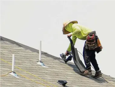  ?? Melissa Phillip / Houston Chronicle ?? Un trabajador de la construcci­ón ayuda a colocar el techo de una casa a lo largo de Spring Stuebner Rd. cerca del Grand Parkway el miércoles 21 de junio de 2023 en Spring, al norte de Houston.