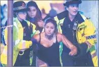  ?? JOEL GOODMAN / DFIC ?? Police officers assist an injured woman after the Manchester Arena bombing attack on Monday evening. Many at the concert were young pop fans and parents.