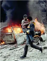  ??  ?? Un bambino soccorso a Hamouria, regione di Ghouta, enclave di ribelli alle porte di Damasco, dopo un raid aereo delle forze siriane e russe (Afp)