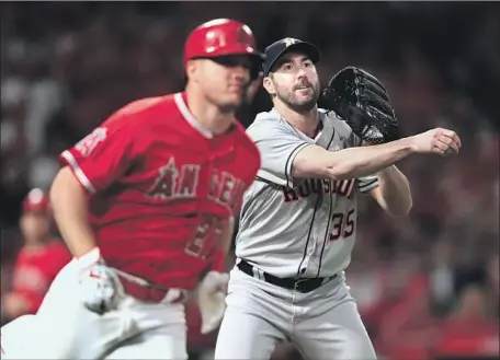  ?? Sean M. Haffey Getty Images ?? JUSTIN VERLANDER THROWS OUT Mike Trout, who hit an easy grounder back to the mound on a check swing with runners on second and third and two outs in the eighth inning. Verlander threw his first shutout in three years, giving up only five hits.