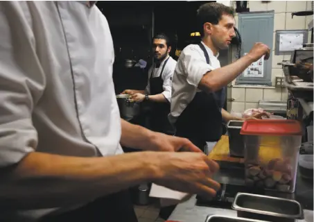  ?? Leah Millis / The Chronicle ?? Sous-chef Clement Lopez (left), line cook Gabriel Diaz, a former stagiaire, and sous-chef Dan Filice work in the kitchen of La Folie in San Francisco, where chef-owner Roland Passot has largely ended the practice of taking on the interns.