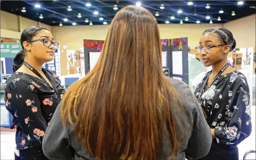  ?? PHOTOS CONTRIBUTE­D BY CHRISTINA MATACOTTA ?? Adriana Peguero (left) and Ronia Ufomadu (right) of Archer High present a STEM project on plant science Feb. 21 at Gwinnett’s science fair. Shiloh Middle, with 95% minority kids, 32% economical­ly disadvanta­ged and 13% whose native language isn’t English, had the most kids move on to state competitio­n.