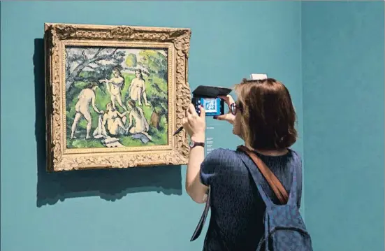  ?? MANÉ ESPINOSA ?? Una visitante fotografía con su móvil Cinco bañistas de Paul Cézanne, obra que luego formaría parte de la colección de Picasso