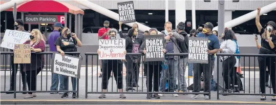  ?? NICOLE CRAINE/THE NEW YORK TIMES ?? Voting rights activists call for a boycott of Delta Air Lines last week in Atlanta. Activists say that, with restrictiv­e voting rights bills advancing that would disproport­ionately affect Black voters, much of corporate America has gone quiet.