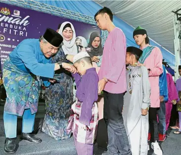  ??  ?? Festive treat: Dr Ahmad Zahid and wife Datin Seri Hamidah Khamis giving out ‘duit raya’ to the orphans during his Hari Raya Aidilfitri open house at Sri Satria in Putrajaya.