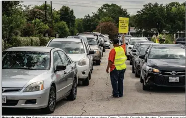  ?? (The New York Times/Go Nakamura) ?? Motorists wait in line Saturday at a drive-thru food-distributi­on site at Notre Dame Catholic Church in Houston. The event was held to help families affected by the coronaviru­s pandemic. More photos at arkansason­line.com/823covid/.