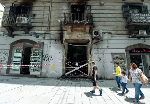  ??  ?? Stupore Incredulit­à dei passanti e dei turisti nell’osservare l’ingresso annerito del bar, oggetto di un attentato dinamitard­o l’altra notte Le fiamme hanno avvolto il pianterren­o e i locali al primo piano (foto sotto)
seminando paura tra i passanti e...