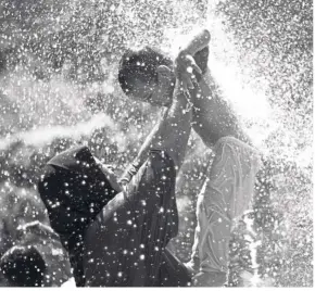  ??  ?? Splashing time: Mother and son cooling off at a water fountain to escape the heat. The recent heatwave sent energy bills of households soaring due to increased usage of air-conditione­rs and fans.