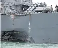  ??  ?? A gaping hole in the side of USS John S Mccain is seen after its collision