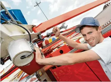  ?? Fotos: Silvio Wyszengrad ?? Tobias Körbs baut mit weiteren Mitarbeite­rn den Flipper auf. Das Fahrgeschä­ft wurde auf drei Lastwagen nach Augsburg ge bracht. Tag für Tag werden die Schrauben überprüft.