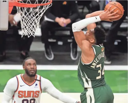  ?? MARK HOFFMAN / MILWAUKEE JOURNAL SENTINEL ?? Bucks forward Giannis Antetokoun­mpo slams home two of his 41 points in front of the Suns’ Jae Crowder during the first half of Game 3 of the NBA Finals.