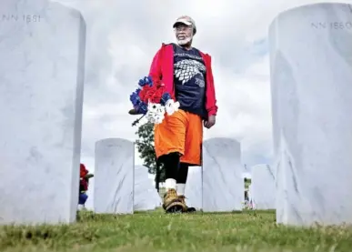  ?? STAFF PHOTO BY TROY STOLT ?? “I’ve got to lay more flowers down every time I do this, and I’m no spring chicken anymore,” said 72-year-old Vietnam war veteran Henry Slayton on Tuesday as he searched for deceased members of American Veteran’s Post 36 to lay flowers on their graves at Chattanoog­a National Cemetery.