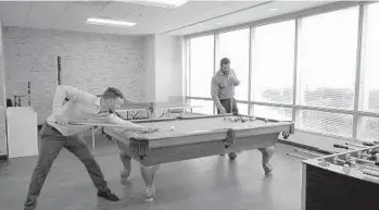  ?? COURTESY PHOTOS ?? Constructi­on software firm e-Builder’s new headquarte­rs includes amenities such as a pool table and foosball.