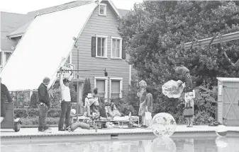  ?? PHOTOS BY SAEED ADYANI, NETFLIX ?? Lauren Graham and Alexis Bledel, seated, work with crew members on the set. “It’s been exactly like the old show and then completely new and different,” Graham says. “Just a little grown up.”