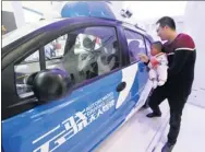  ?? WU HUANG / FOR CHINA DAILY ?? Visitors look at a Baidu self-driving car at an exhibition in Hangzhou, Zhejiang provnce.