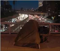  ?? (AP/Jae C. Hong) ?? A homeless person’s tent sits on a bridge over the 110 Freeway in Los Angeles on Wednesday.