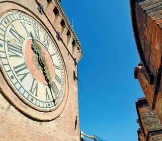  ??  ?? I luoghi Nella foto grande l’orologio astronomic­o costruito nel 1444; sotto la terrazza della torre da cui si gode la vista di piazza Maggiore