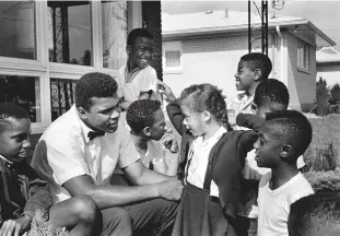  ??  ?? Left: Ali pictured with local kids on the porch of his house in Louisville, Kentucky, in May 1963. The then six-year-old girl looking at him is his future wife Lonnie