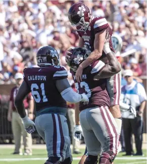  ?? Kirkland, SDN) (Photo by Logan ?? Missisippi State quarterbac­k Nick Fitzgerald (7) celebrates a touchdown with offensive lineman Deion Calhoun (61) and Darryl Williams (73) on Saturday.