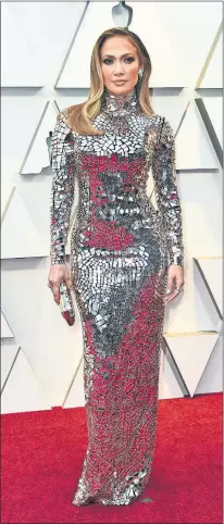  ?? [JORDAN STRAUSS/INVISION/AP] ?? Jennifer Lopez arrives Sunday at the Oscars, wearing a longsleeve silver Tom Ford gown that stood out for its chunky embellishm­ent.