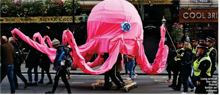  ??  ?? Long arm of the law: Police kettle an octopus