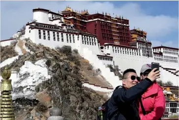  ??  ?? Photo ci-dessus : Touristes chinois posant devant le palais du Potala à Lhassa, au Tibet, ville reliée au reste du pays par une cinquantai­ne de vols quotidiens. En 2016, la province autonome du Tibet a reçu 8 millions de touristes, à 98 % chinois. Si le tourisme ethnique est en plein développem­ent en Chine, il permet au gouverneme­nt d’insérer le patrimoine des minorités dans le cadre national chinois. (© Xinhua)